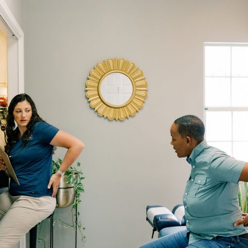 Dr Dalton educating a patient on at home exercises to help with pain and functional rehab at Seven Bridges Chiropractic